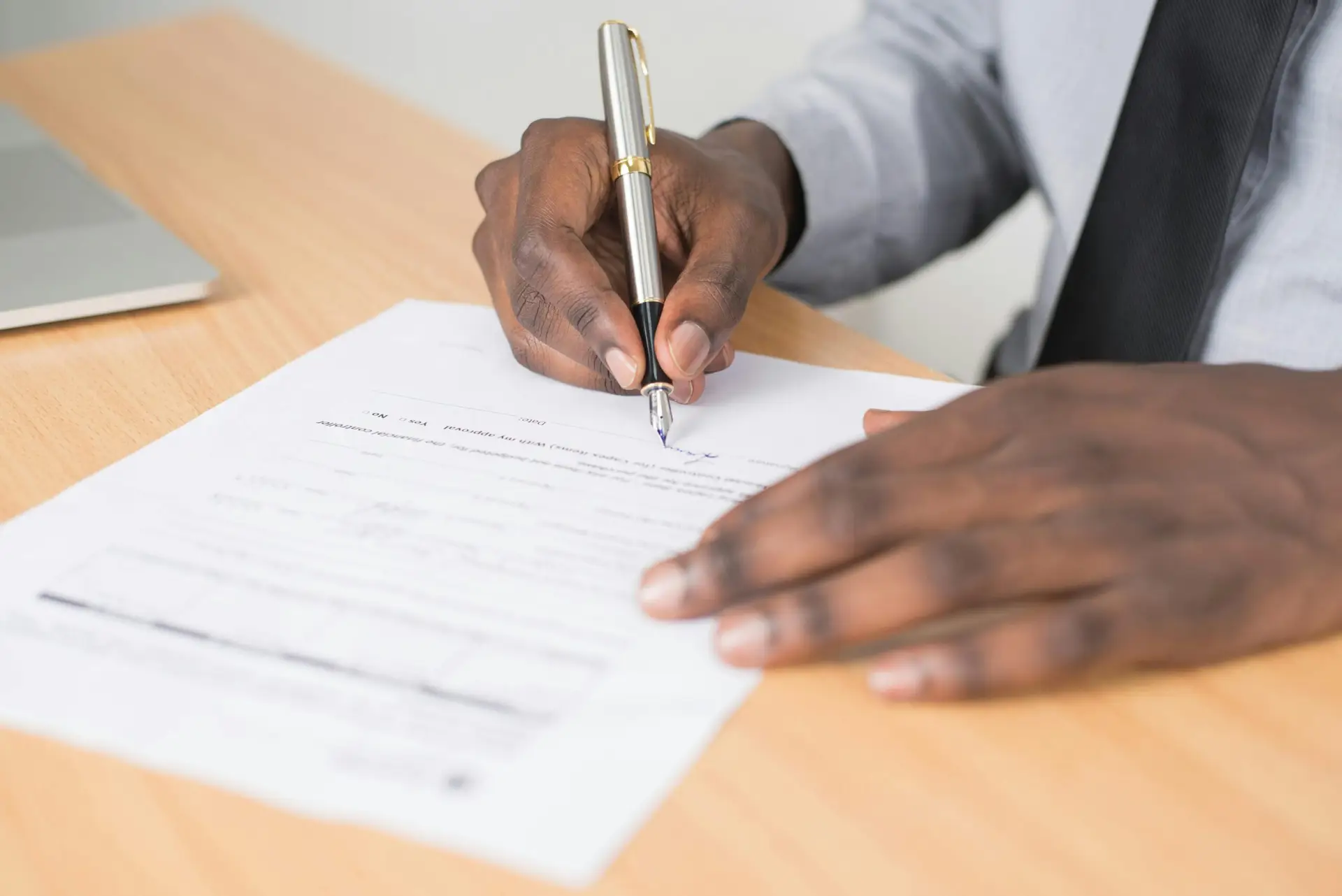 Writing a Will in Poole and Bournemouth? Get in Contact Today Person signing document with pen.